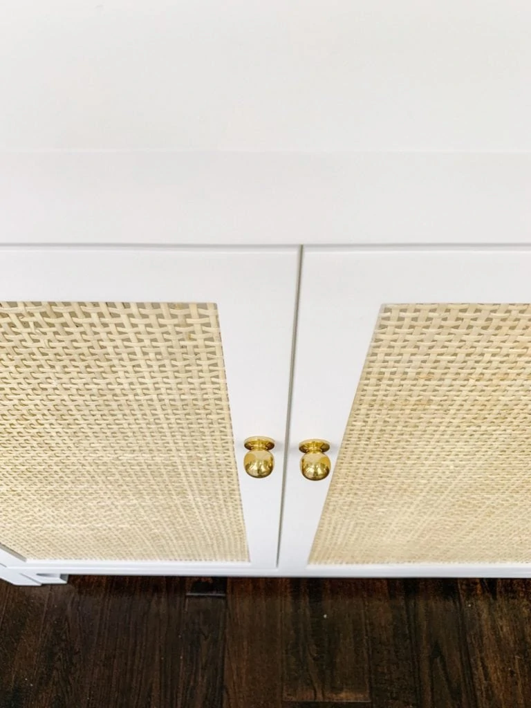 A white cabinet with cane inset doors. This post provides a variety of cane furniture and decor at a variety of price points for all budgets!