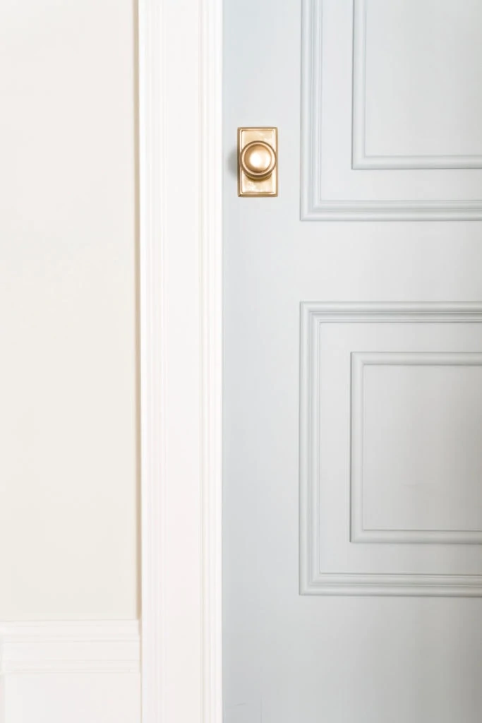 An interior door painted Benjamin Moore Boothbay Gray. I love the gold door hardware paired with this pretty blue gray paint color.