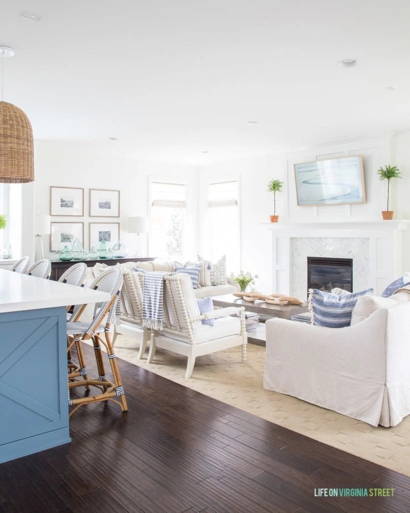 A spring living room and kitchen decorated in blue and white stripes. I love the linen sofas paired with the white spindle bobbin chairs!