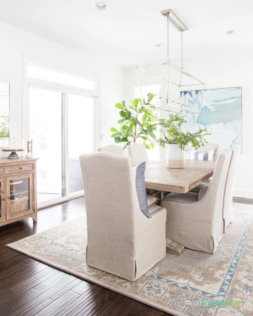 The vintage inspired rug with the wooden table with fabric chairs in the living room.