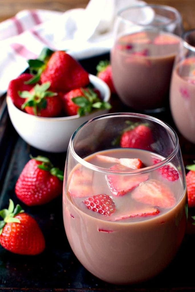 Chocolate Sangria with strawberries in the cup and on the table.