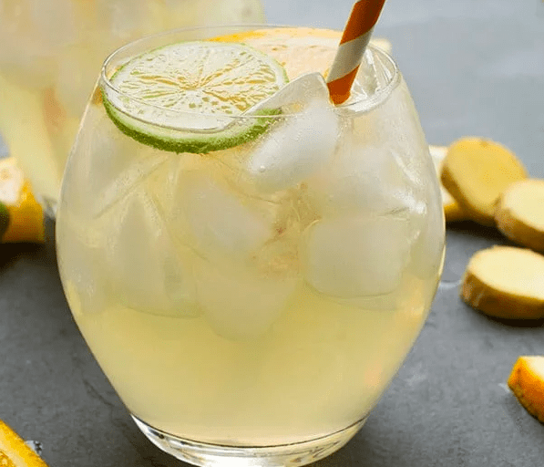 White Wine And Ginger Beer Sangria in a glass with a red and white straw.