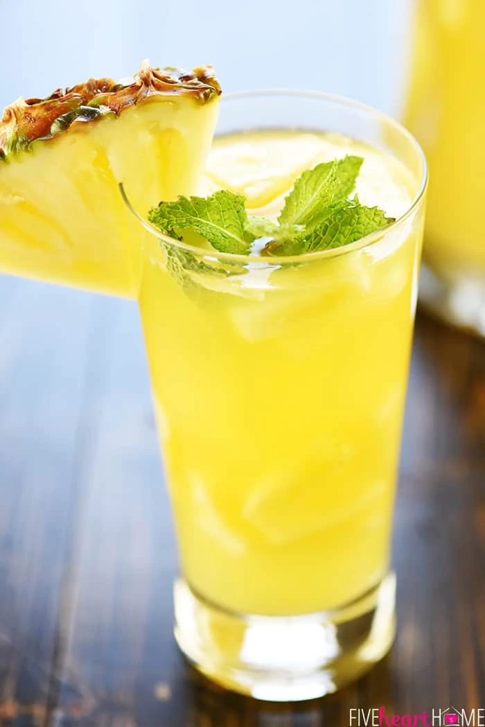 Sparkling Pineapple Sangria with a slice of pineapple on the rim of the cup.