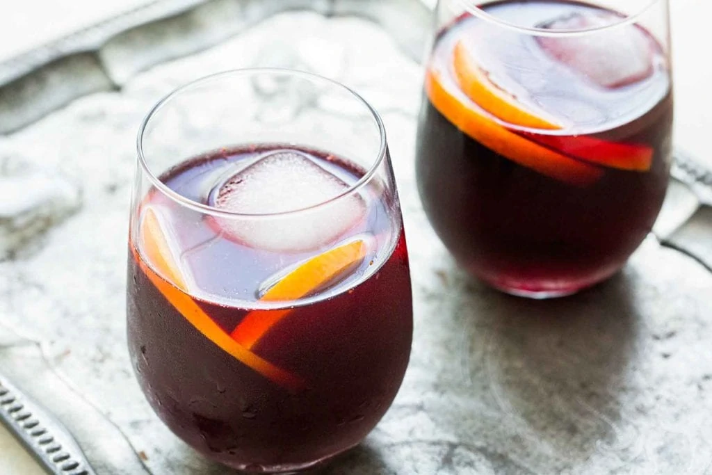 A dark Mixed Berry Sangria on a silver tray.