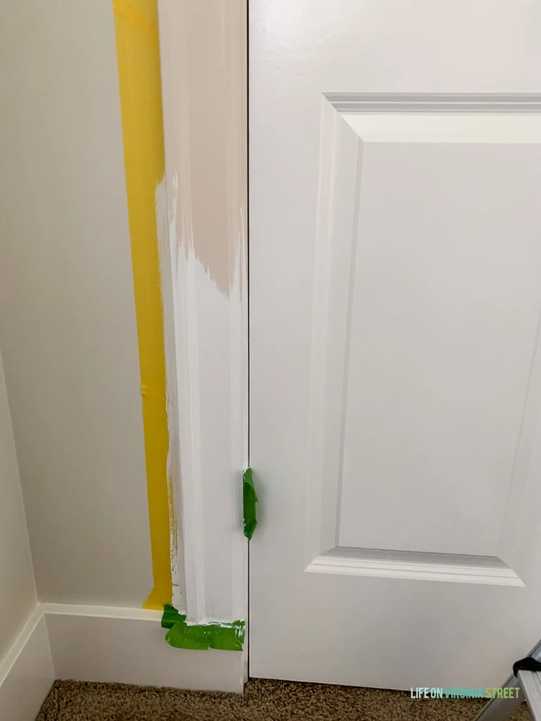 Painting the trim beside the doors.