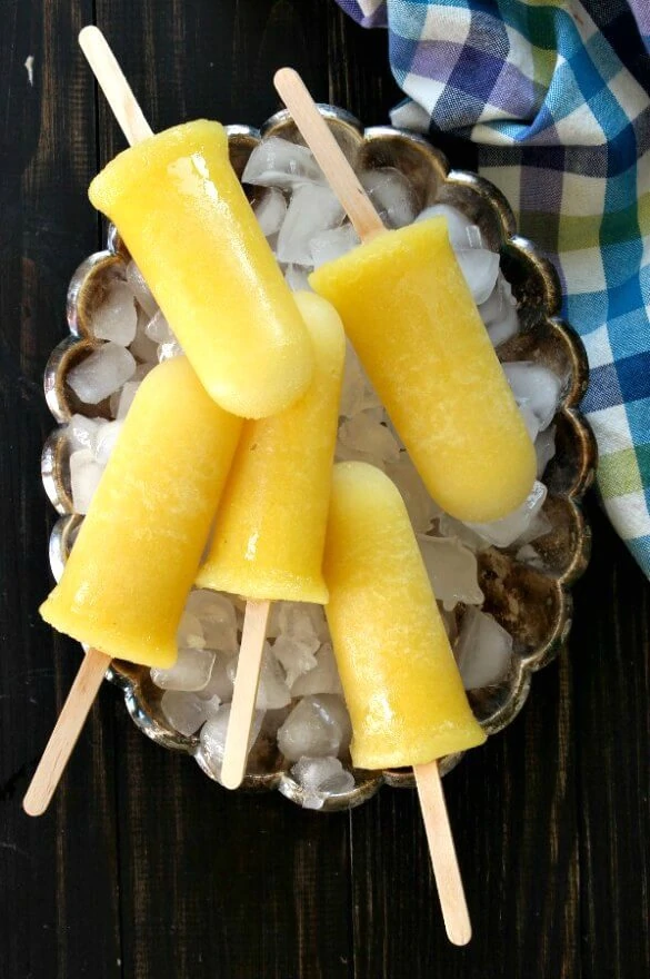 Pineapple Kiwi Popsicles on a bowl full of ice.