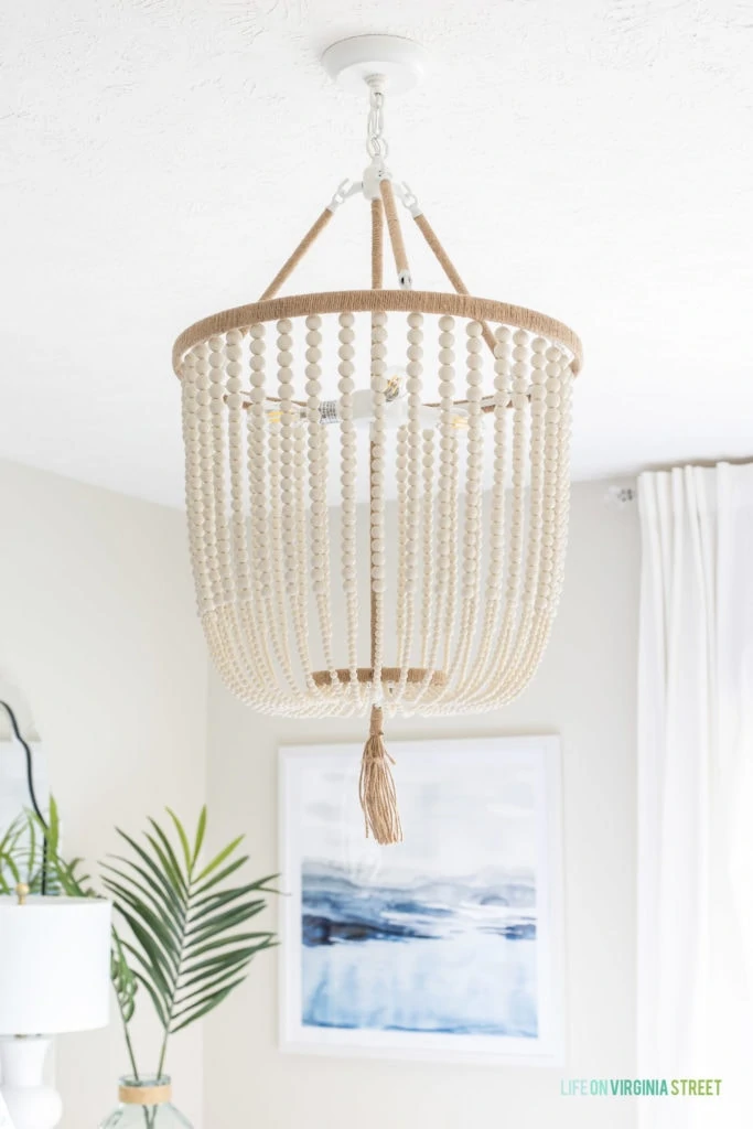 A white beaded chandelier hanging above the bed.