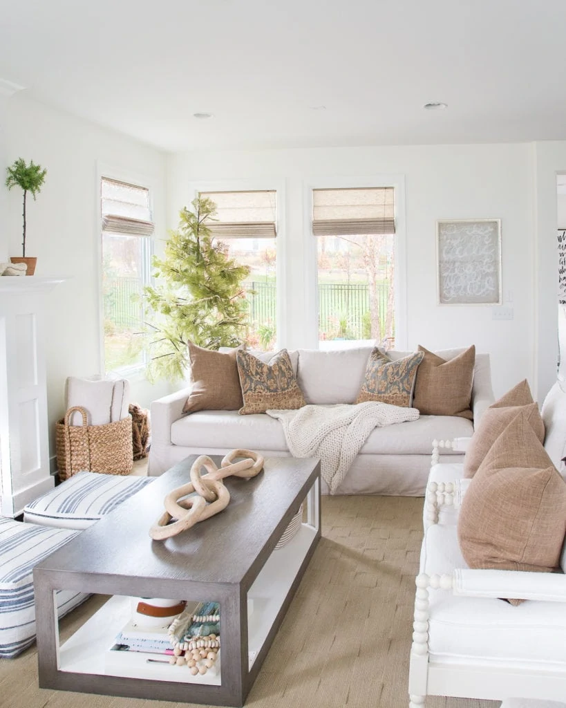 A fall living room decorated in brown tones with blue and white accents. Walls are Benjamin Moore Simply White.