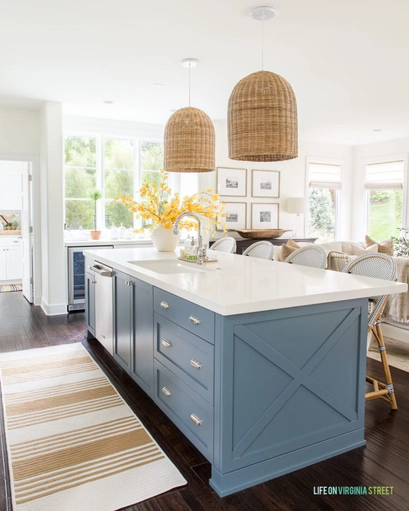 A coastal inspired kitchen with walls and cabinets painted Benjamin Moore Simply White and kitchen island painted Benjamin Moore Providence Blue.