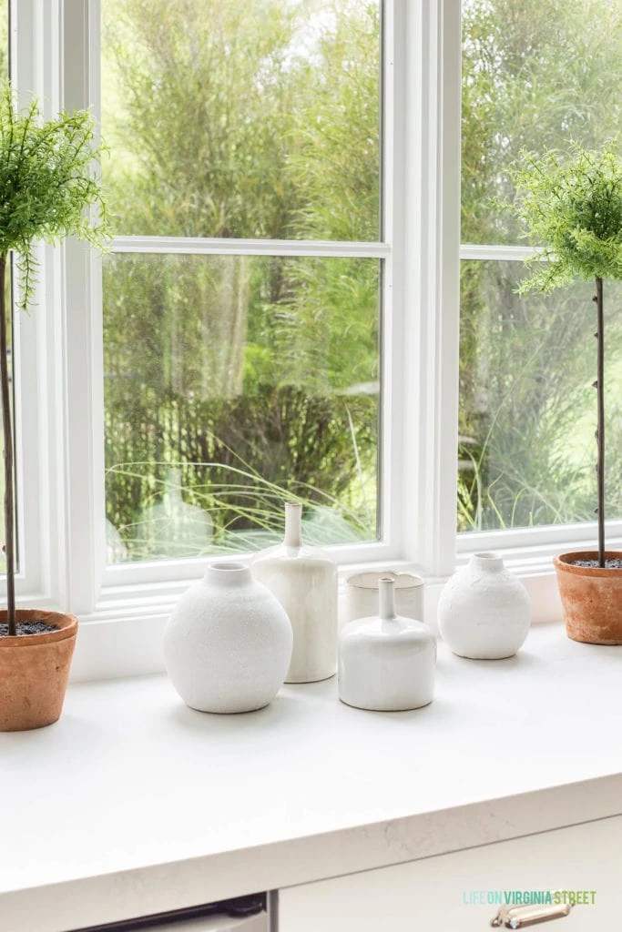 A collection of small white ceramic vases displayed as a grouping.