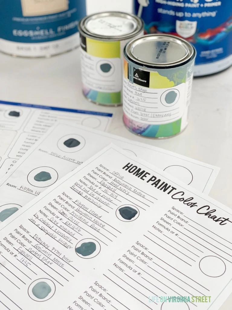 Free printables to organize your whole house paint colors beside cans of paint.