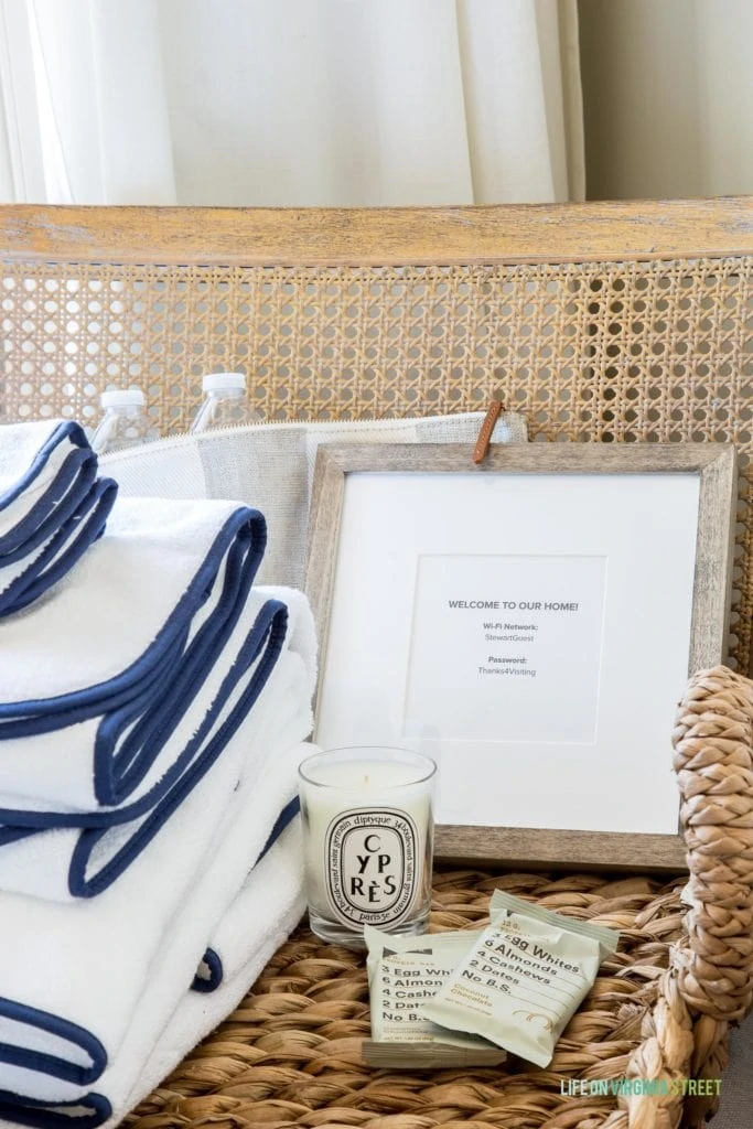 A welcome to our home sign with towels, a candle and soap on the chair.