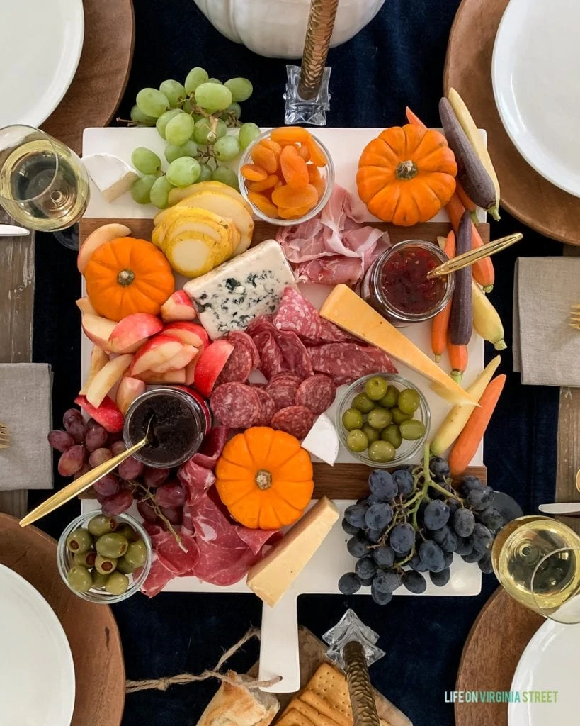 A colorful charcuterie tray that's perfect for your Thanksgiving table setting or fall! Love the addition of pumpkins and harvest veggies!