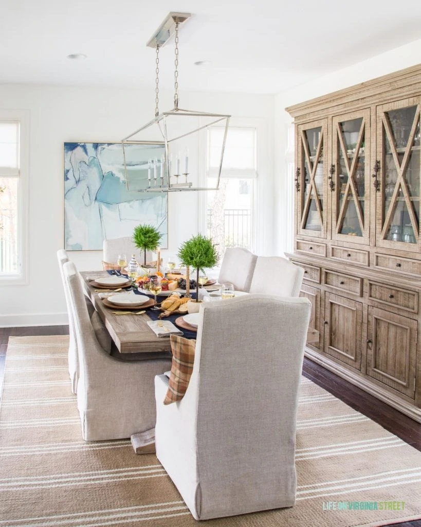 A beautiful and serene Thanksgiving table setting and dining room! Ideas for using neutral colors mixed with shades of blue and brown.