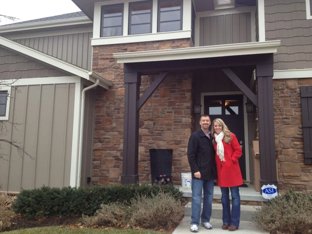 Sarah and Kurt standing in front of their home.