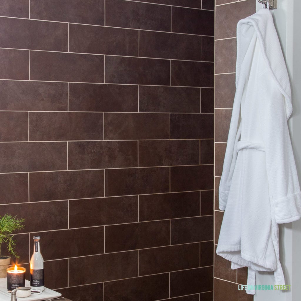 Hooks on the wall with a white robe hanging on it.