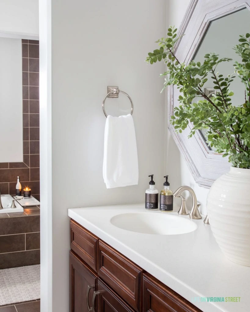 A green plant in a white vase in the bathroom.