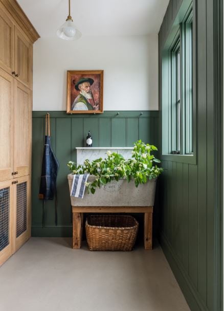 Benjamin Moore Backwoods walls in a mudroom with warm wood cabinets and a large sink.