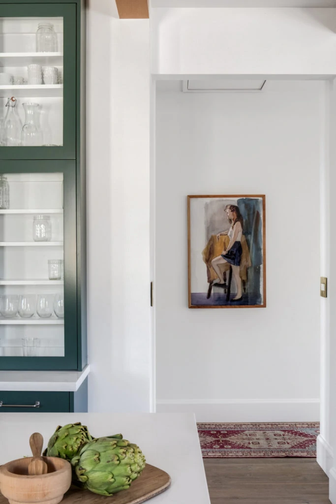 Benjamin Moore Lafayette Green kitchen cabinets with white walls and wood beams on the ceiling.