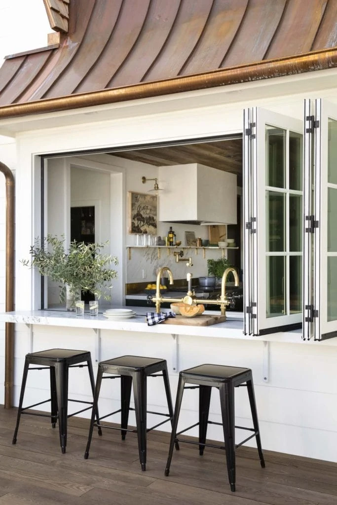 Pool house ideas including this outdoor bar area with folding glass doors on the bar top.