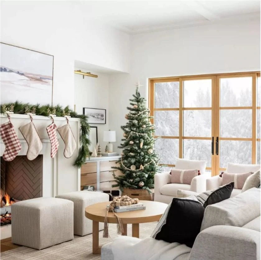 A beautiful living room with white walls, large wood sliding doors and white limestone fireplace. Decorated with the new Studio McGee x Threshold Christmas collection at Target.