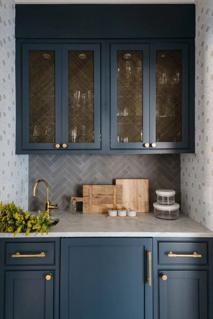 Tudor house renovation ideas like these navy blue cabinets with gold mesh insert in cabinet doors. Perfect for a butler's pantry!