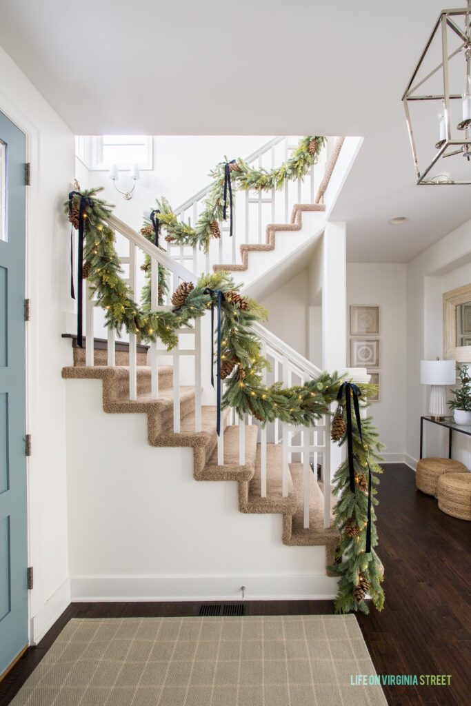 Christmas Decor Favorites in our entryway, including faux garland and fairy string lights!