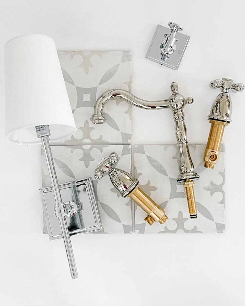 A bathroom design board with a chrome bathroom sconce, patterned porcelain tile that looks like cement tile, a chrome robe hook, and vintage style bath faucets.