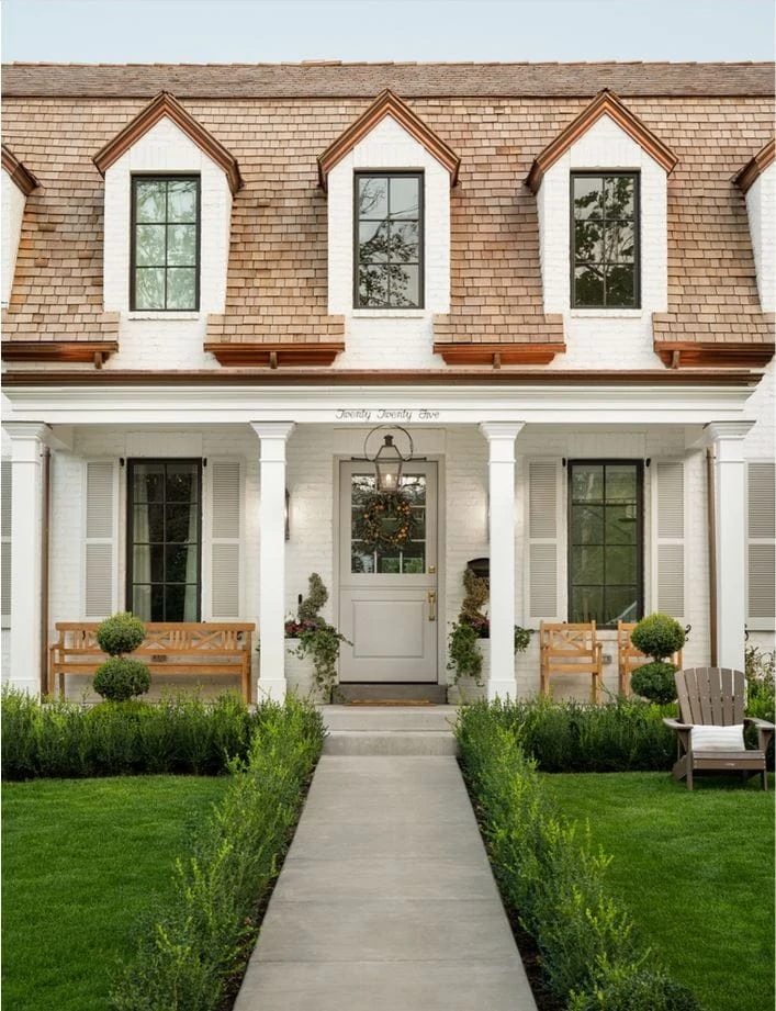 A fresh traditional white painted brick house with copper gutters and wood shingles via The Fox Group.