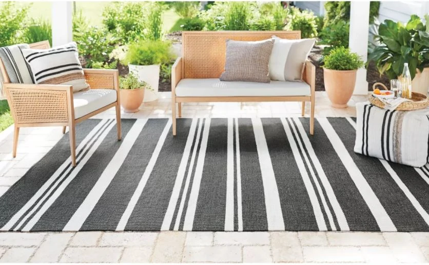 Outdoor cane inspired furniture from the new Studio McGee Target Patio Collection. Also includes a striped out door rug and outdoor poufs and planters.