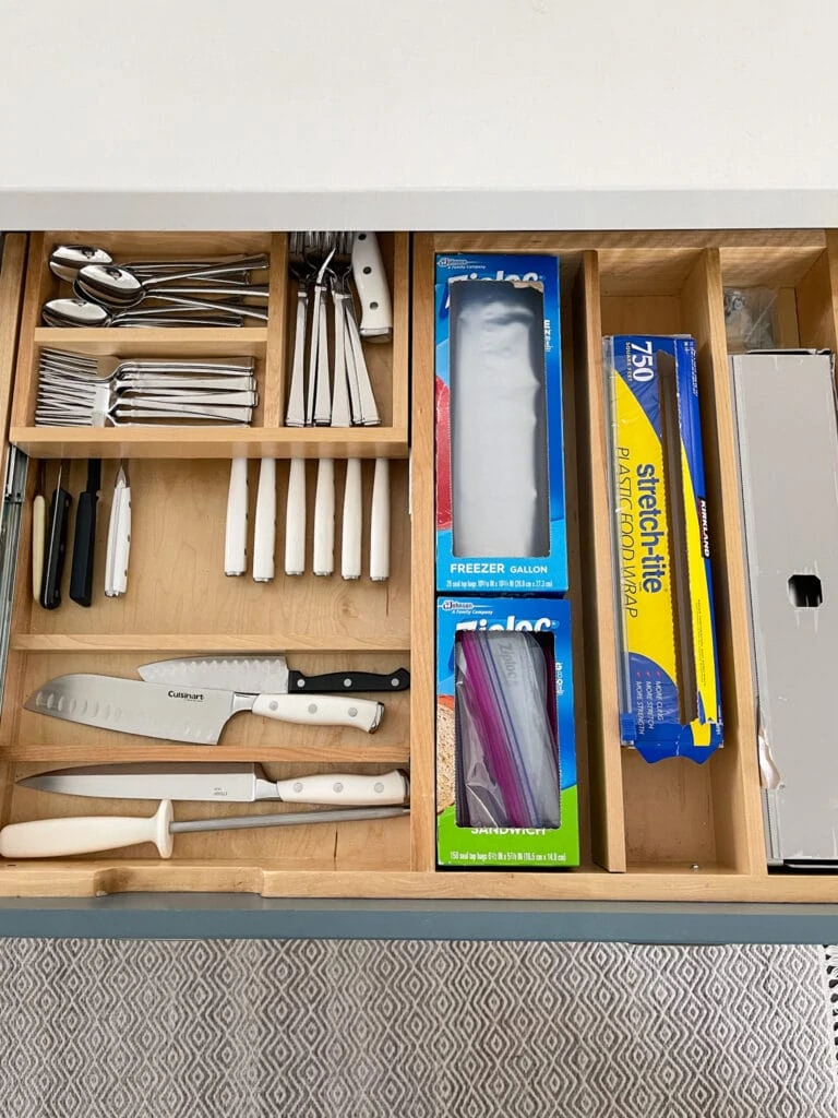 A kitchen drawer with a two levels of storage for flatware and kitchen knives. Also stores cling wrap, foil and baggies.