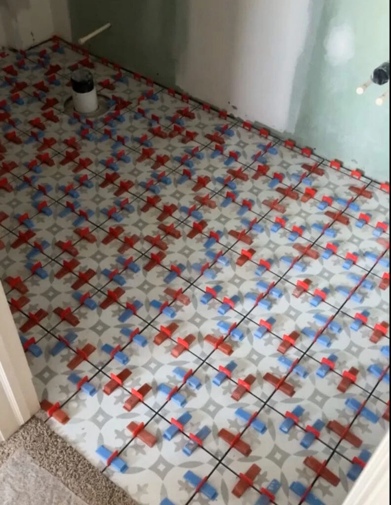 A porcelain tile floor with large spacers during installation.