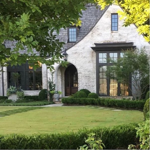 A Tudor exterior limewashed with Romabio limewash to give the brick a, white, aged finish.