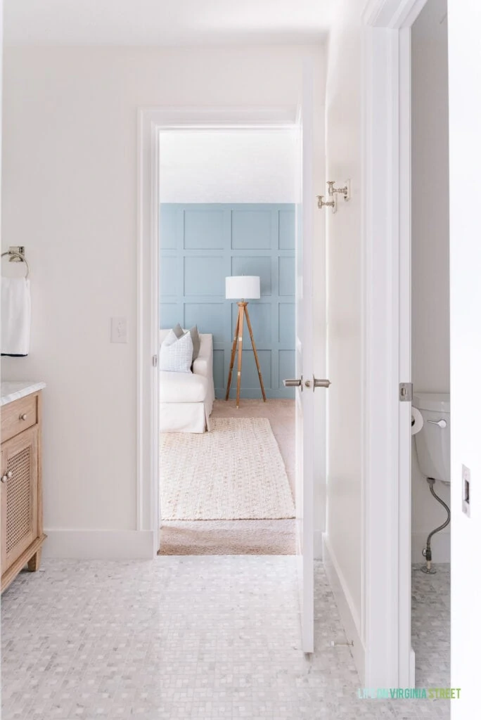 A Jack & Jill bathroom remodel looking into a TV room with blue board and batten grid wall.