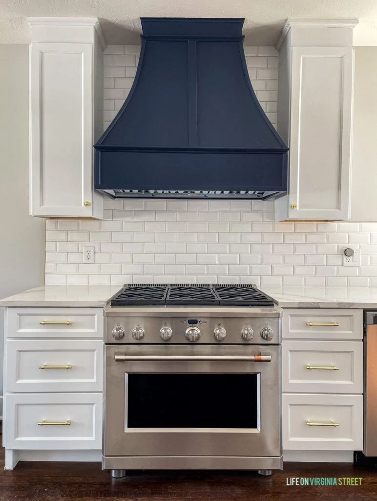 A white kitchen with a range hood painted Sherwin Williams Naval.