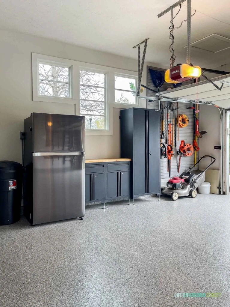 Garage workbench and and organized garage slat wall to store yard tools.