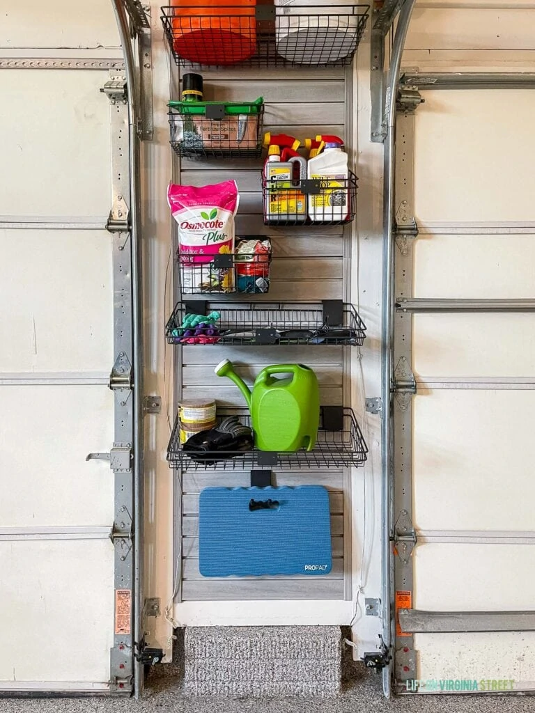 A garage wall for gardening with a slat wall, baskets and hooks to store gardening tools.