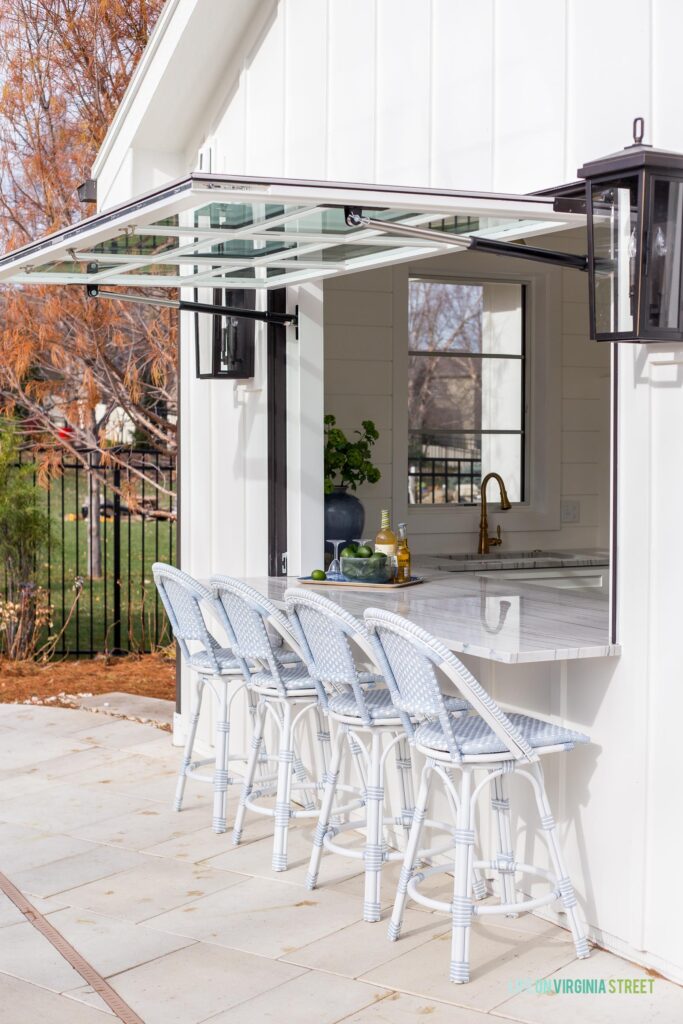 Serena & Lily outdoor counter stools at an indoor/outdoor bar with gas strut window!