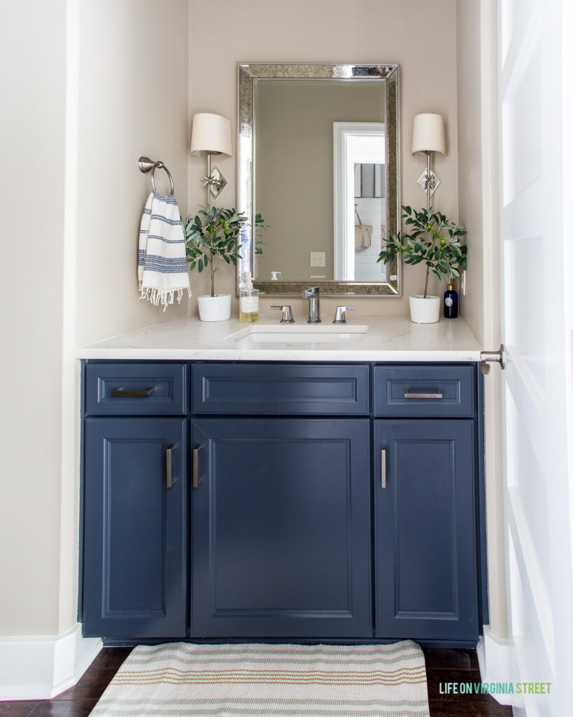 A powder bath vanity painted Benjamin Moore Hale Navy along with Behr Castle Path walls.