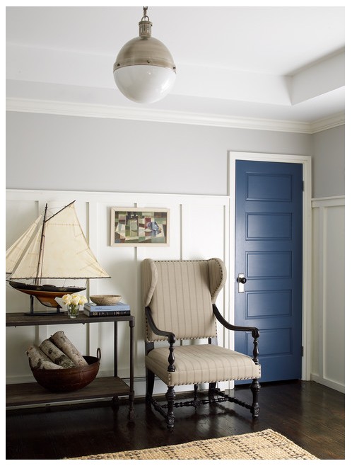 The best gray paint colors, as demonstrated in a room with Benjamin Moore Stonington Gray walls, paired beautifully with white board and batten, a door painted Benjamin Moore Bayard Blue, and a David Hicks pendant light.