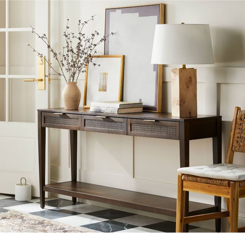 Beautiful new furniture and decor from the new Studio McGee Threshold line at Target! Includes a dark brown cane console table, brown abstract art, a burl wood table lamp, gold gallery frame, and a woven chair.