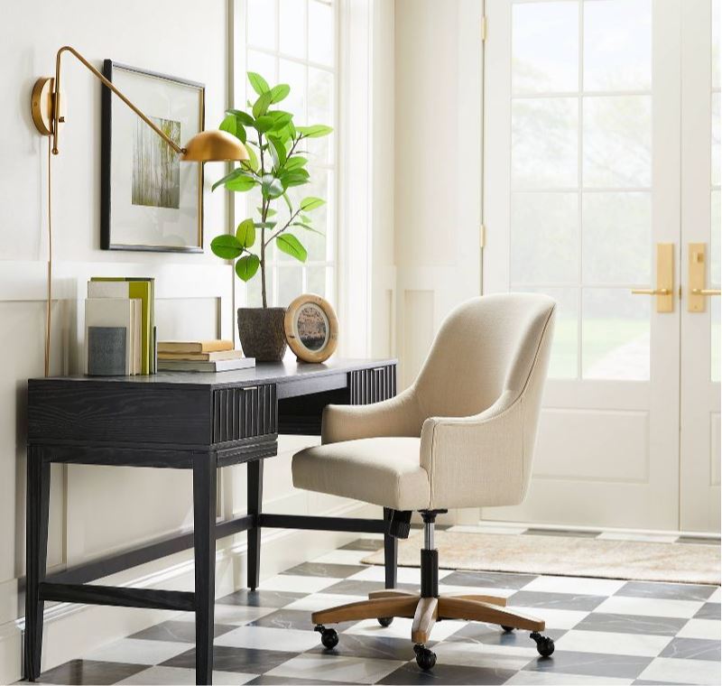 New Releases From Studio McGee including a black scalloped desk, upholstered desk chair, faux banyan tree, gold wall sconce, and gallery wall frame.