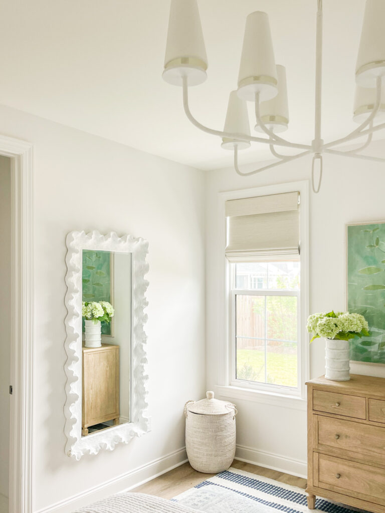 A tall coral style mirror hung on a bedroom wall. This mirror could also work in a bathroom with tall ceilings.
