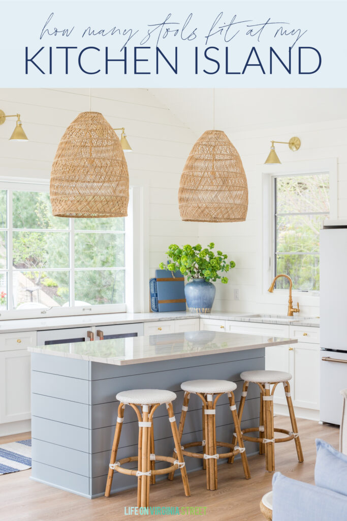Helping answer "how many stools fit at my kitchen island?" this image shows a coastal kitchen with three counter stools at a small blue island.