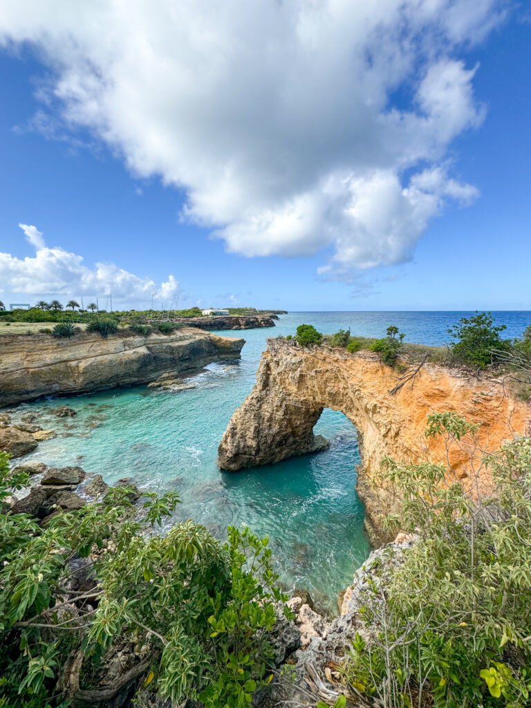 An Anguilla travel guide that shares what to do in Anguilla. This image is of the Anguilla Arch and neighboring beach views.
