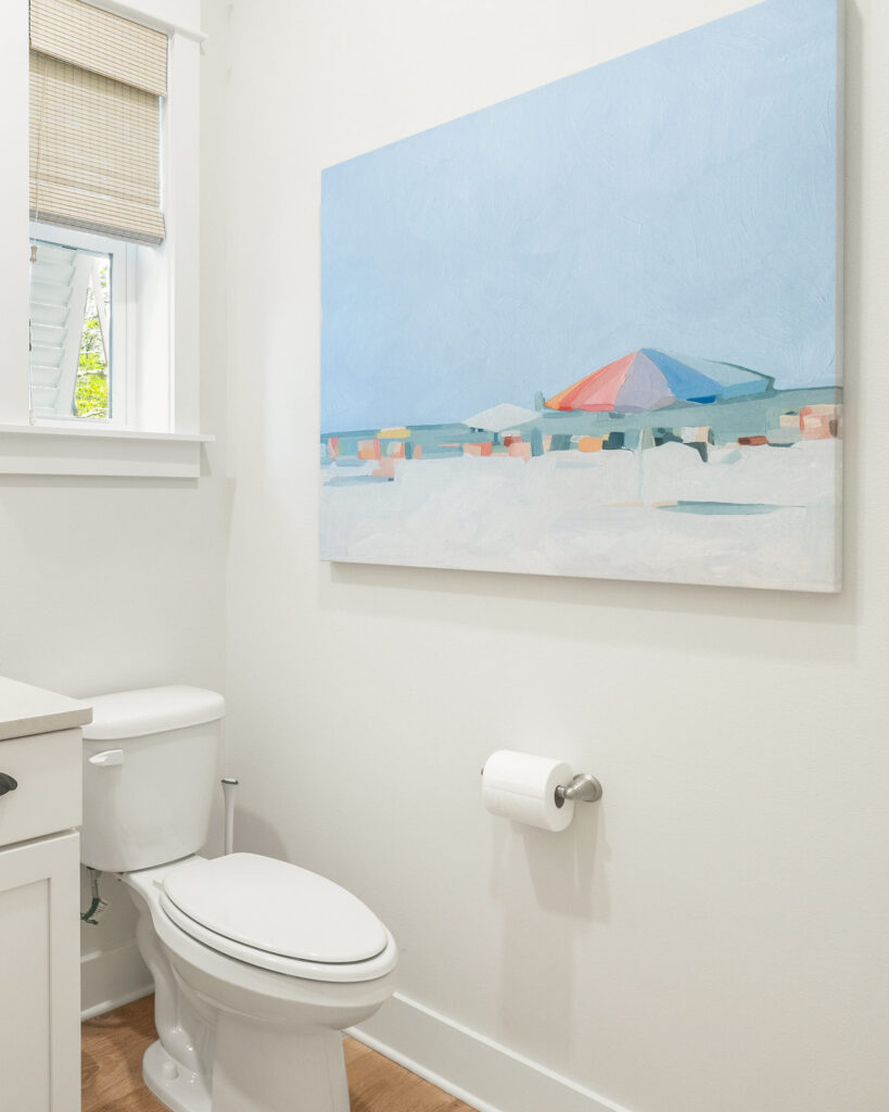 Wayfair Coastal Wall Decor in a bathroom. This oversized artwork canvas features an abstract beach scene with colorful umbrellas.