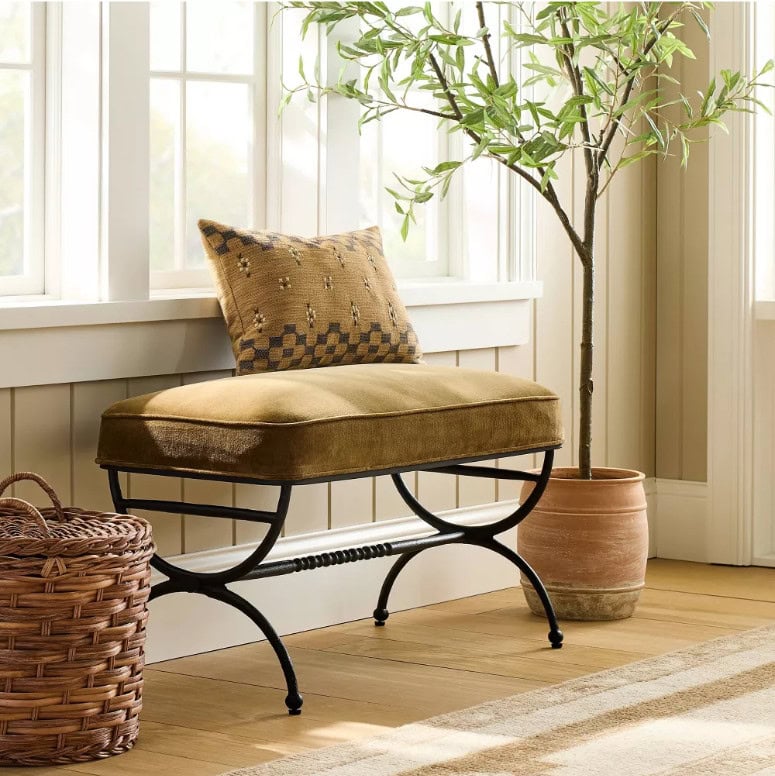 Fall 2025 Studio McGee x Threshold collection at Target includes this upholstered metal bench, beautiful hand-knotted wool rug, a faux olive tree in a cement pot, and dark rattan basket.