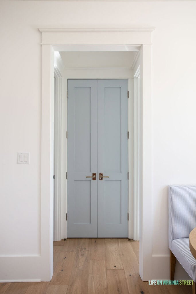 Laundry closet doors painted Benjamin Moore Silver Gray with polished nickel door levers, and Benjamin Moore Chantilly Lace walls and trim.